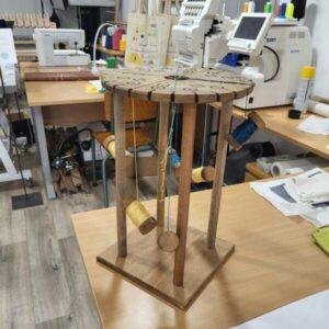 Professional wooden bobbins and upcycled threads prepared for a workshop Kumihimo braiding experience at Atelier de Tressage. Discover Kumihimo braiding