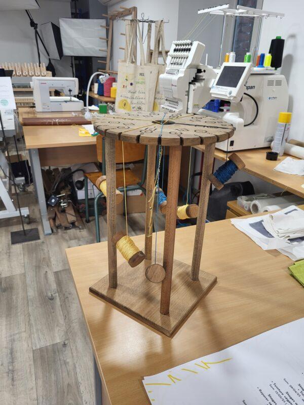 Professional wooden bobbins and upcycled threads prepared for a workshop Kumihimo braiding experience at Atelier de Tressage.