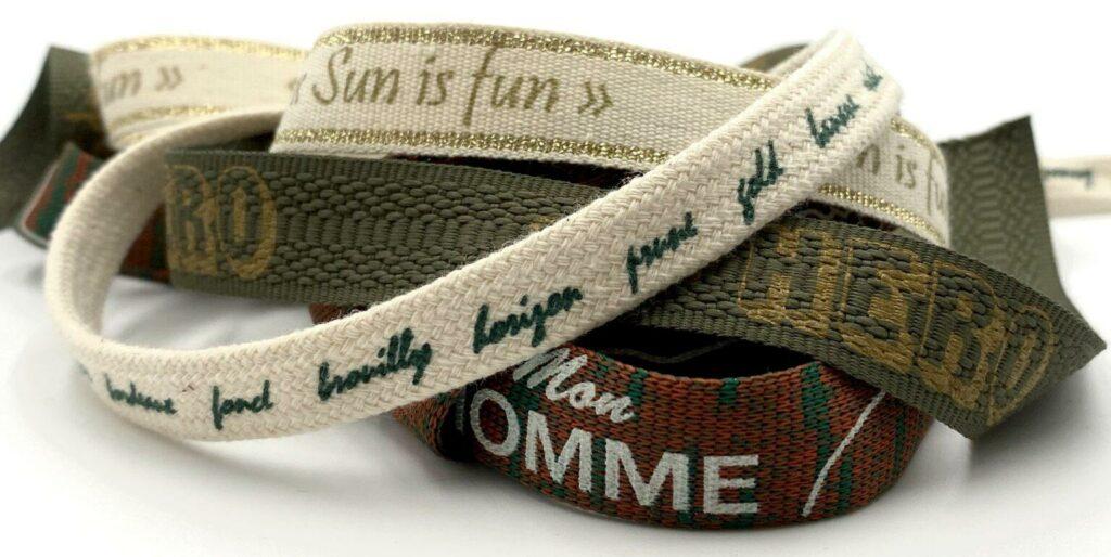 Custom branded text and logos screen-printed onto durable narrow braided straps and textile ribbons