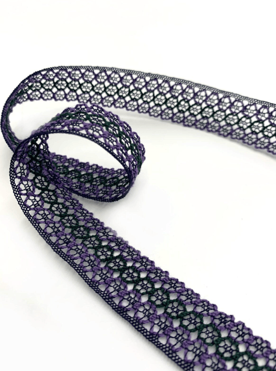 Close-up of intricate handmade bobbin lace, showing the detailed woven thread patterns and delicate geometric structure.