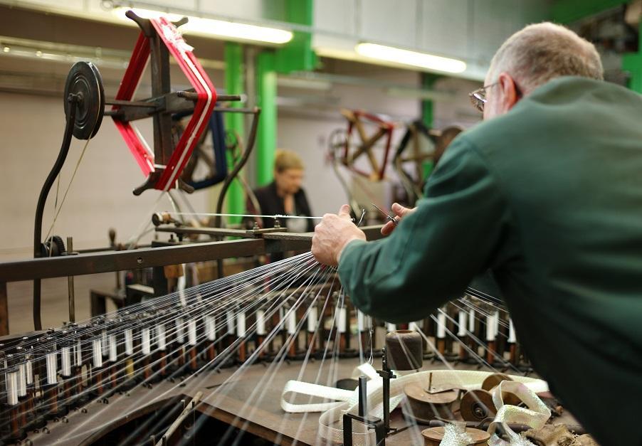 Guy on the machines at SCF History of wooden braiding looms